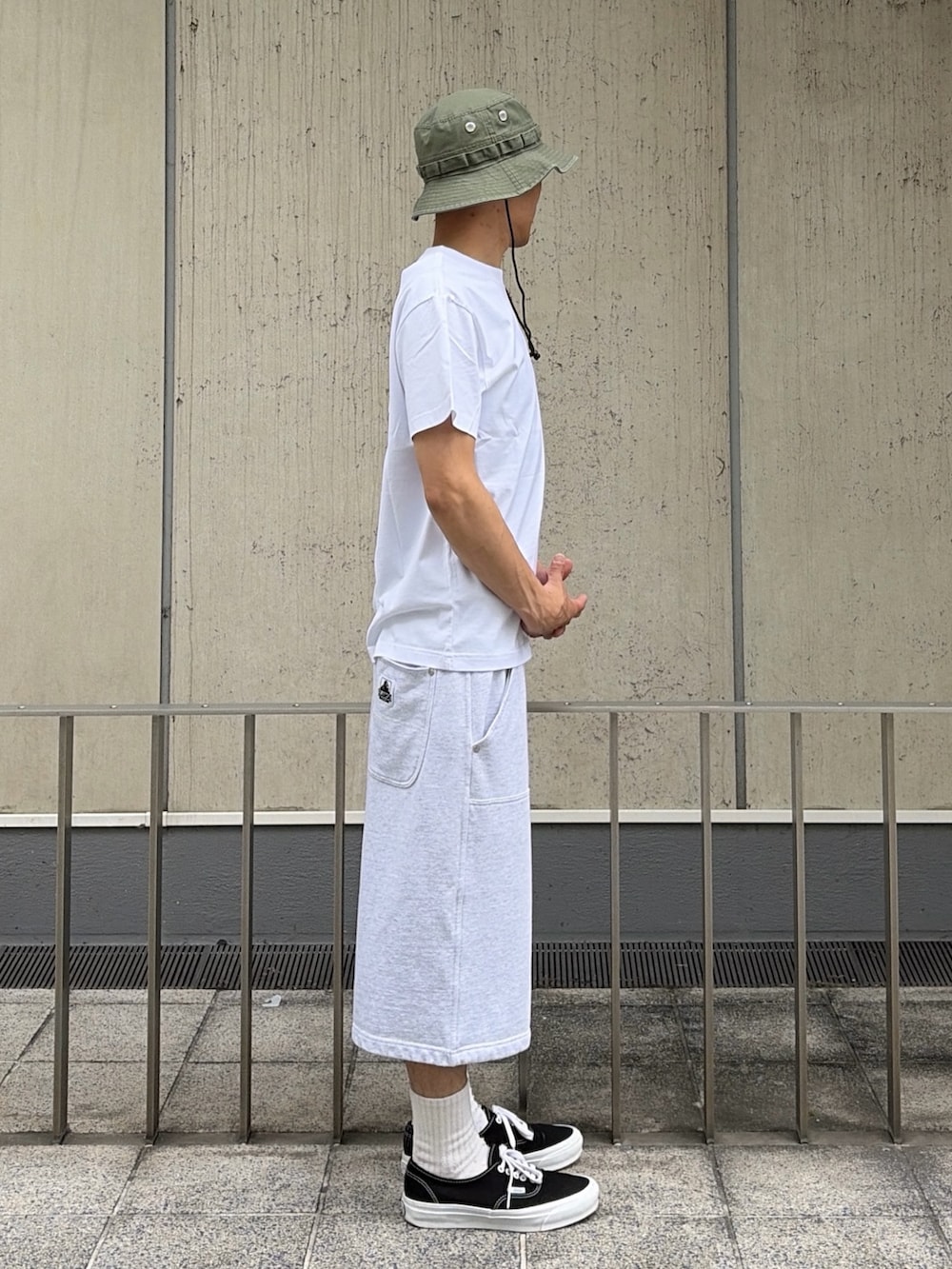 グレー系のスウェットパンツ、ブルー系のベルト、ブラック系のハットを着用したメンズの夏コーディネートの3枚目の写真