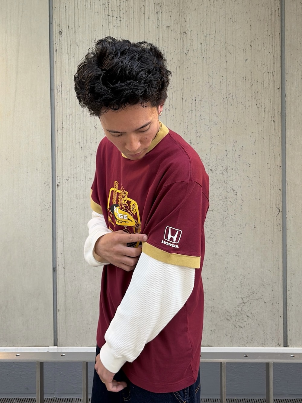 レッド系のTシャツ/カットソー、ブルー系のデニムパンツ、ホワイト系のTシャツ/カットソーを着用したメンズの春コーディネートの6枚目の写真