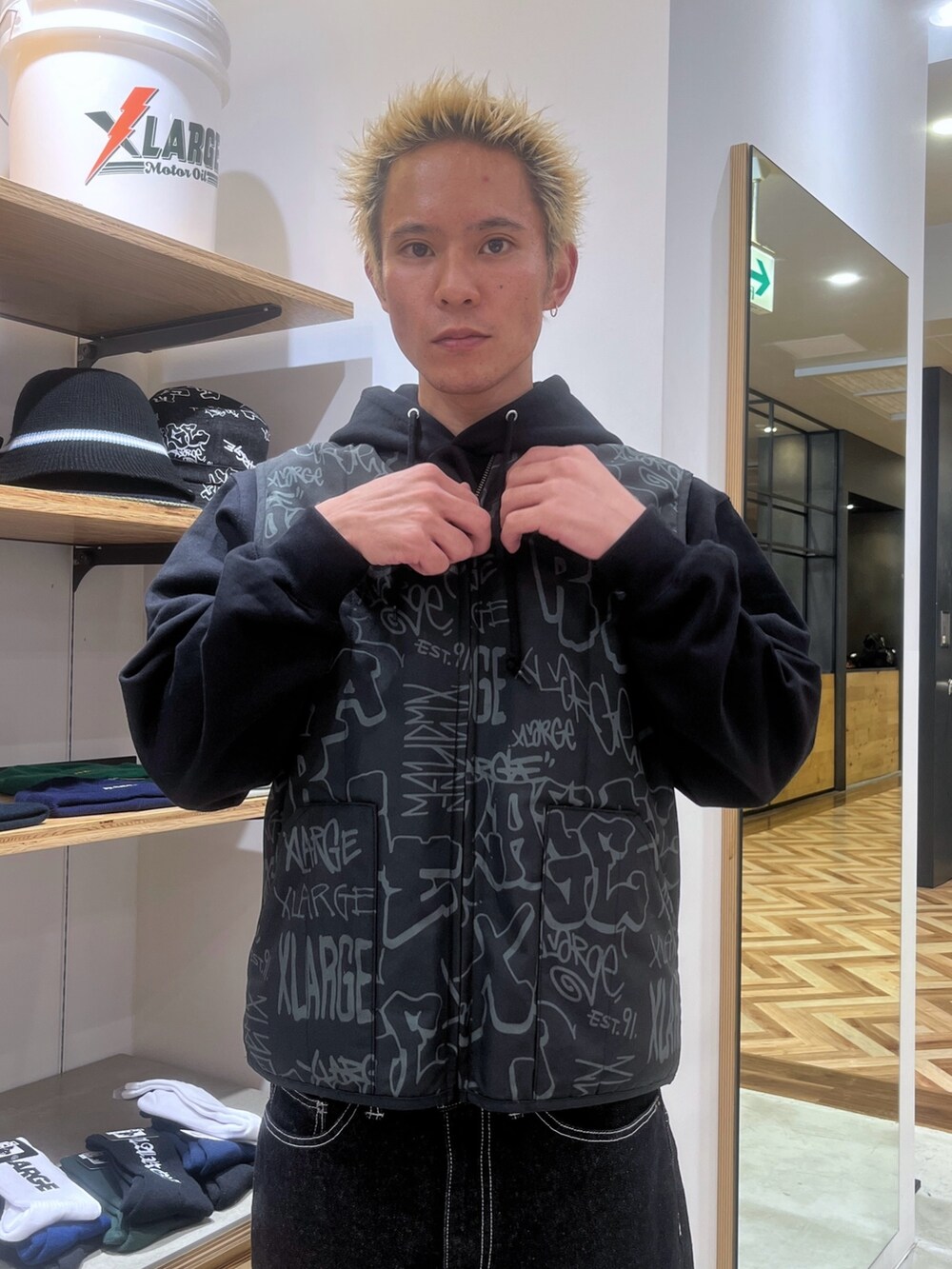 ブラック系のベスト、ブラック系のパーカー、ブラック系のデニムパンツを着用したメンズの秋コーディネートの5枚目の写真