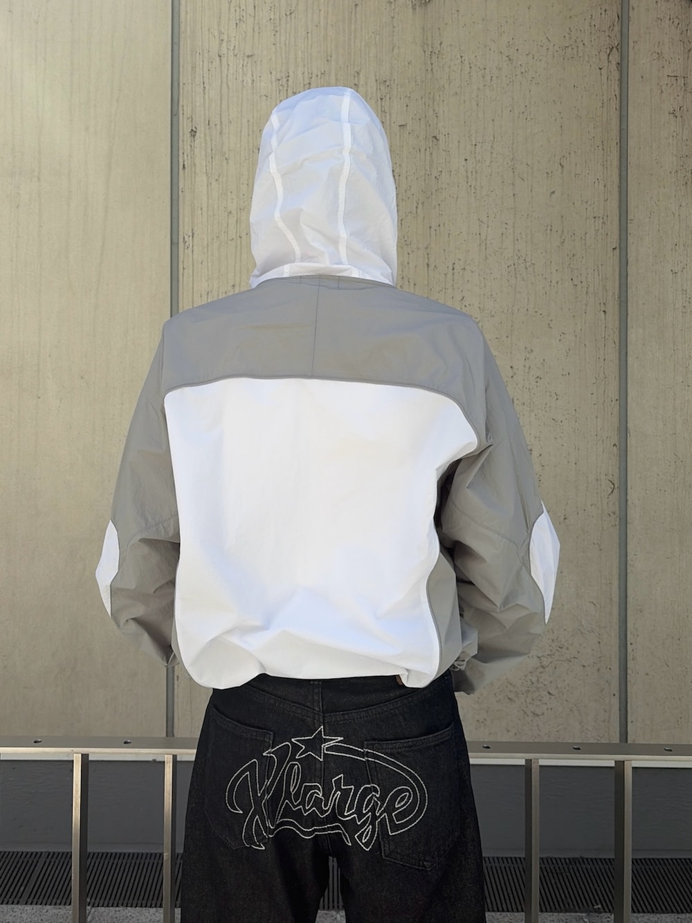 ブルー系のナイロンジャケット、ブラック系のデニムパンツ、ピンク系のニットキャップ/ビーニーを着用したメンズの春コーディネートの7枚目の写真