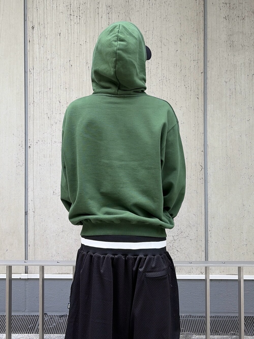 グリーン系のパーカー、ブラック系のその他パンツ、ブラック系のキャップを着用したメンズの夏コーディネートの9枚目の写真