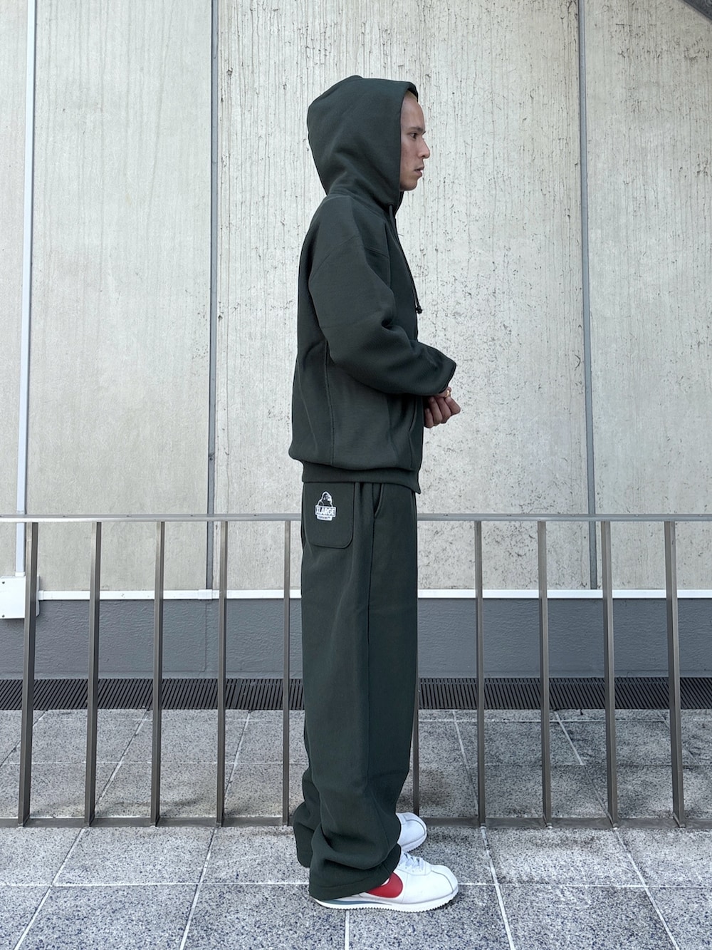 グリーン系のパーカー、グリーン系のスウェットパンツ、ブラック系のキャップを着用したメンズの秋コーディネートの5枚目の写真