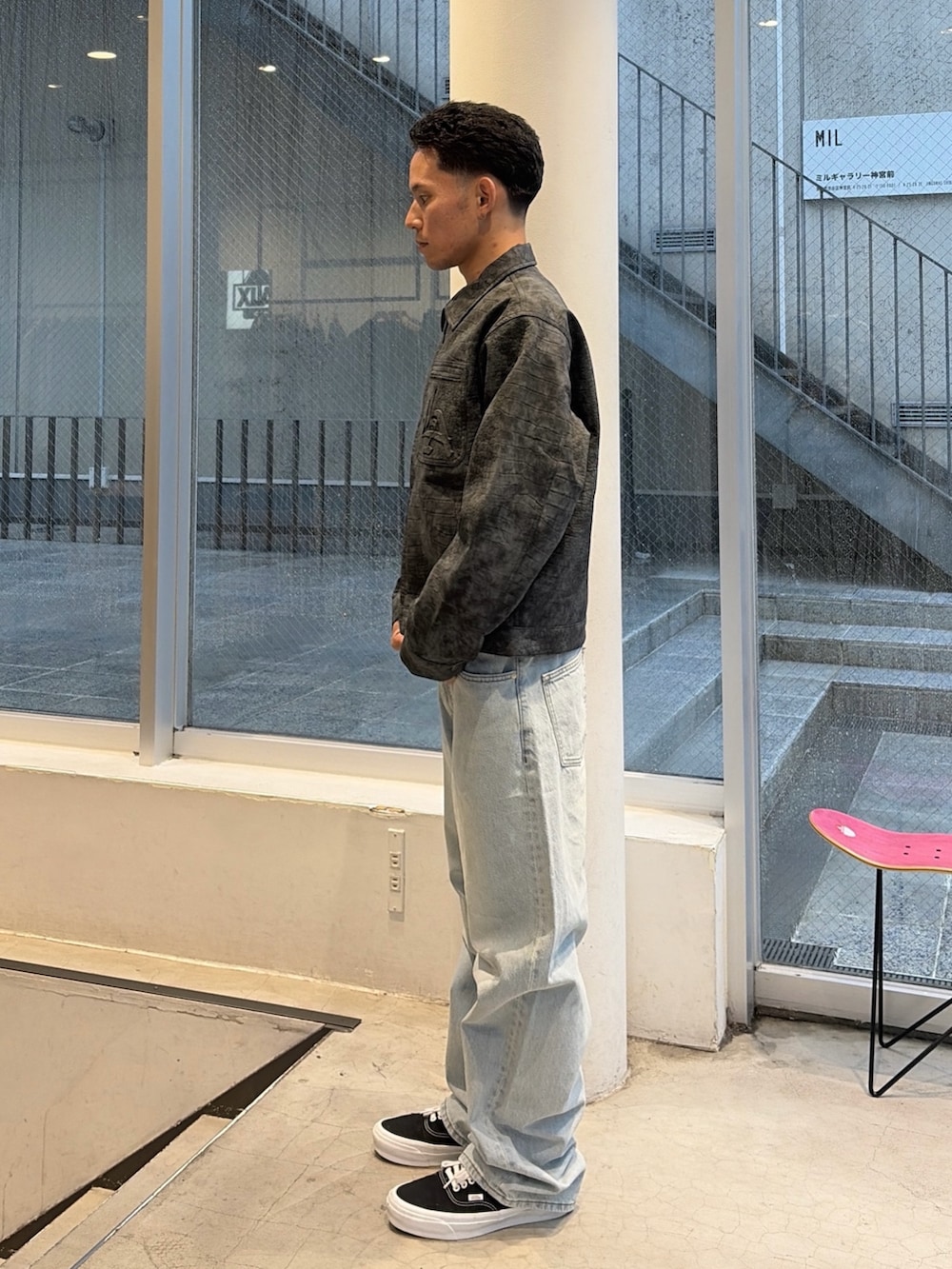 ブラック系のブルゾン、ブルー系のデニムパンツを着用したメンズの秋コーディネートの2枚目の写真