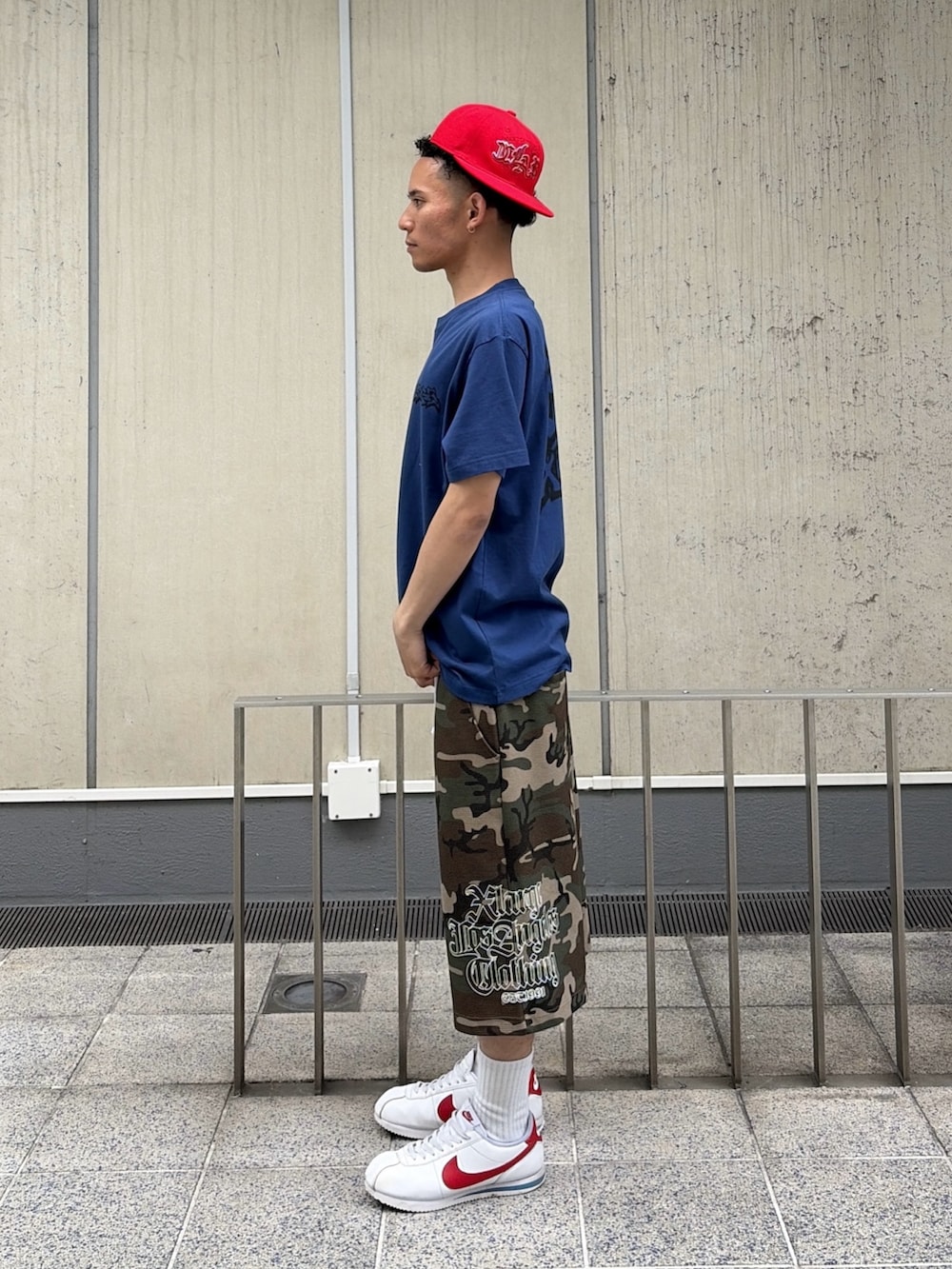 ブルー系のTシャツ/カットソー、その他のその他パンツ、レッド系のキャップを着用したメンズの春コーディネートの2枚目の写真