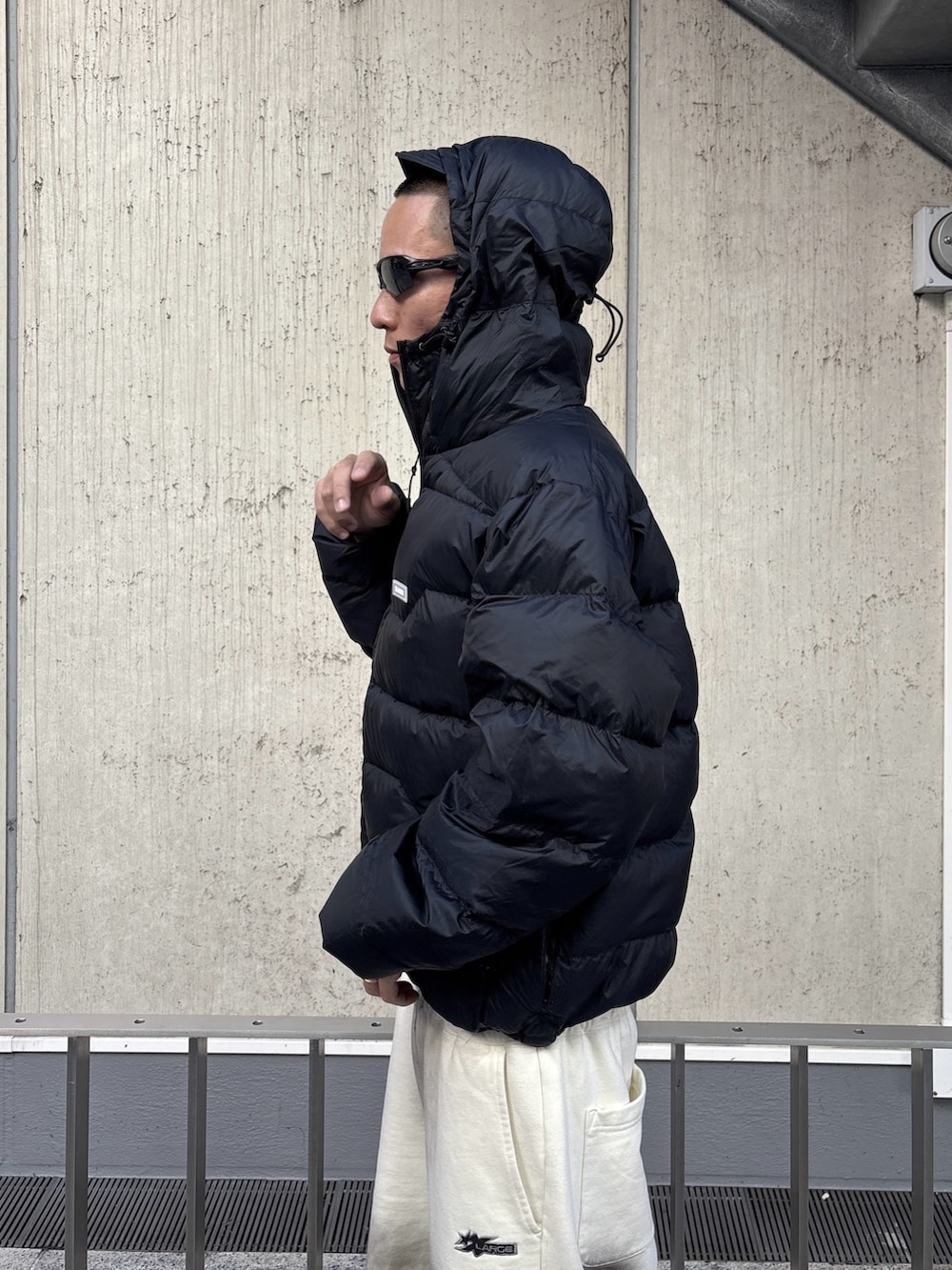 ブラウン系のダウンジャケット/コート、ホワイト系のスウェットパンツを着用したメンズの秋コーディネートの8枚目の写真