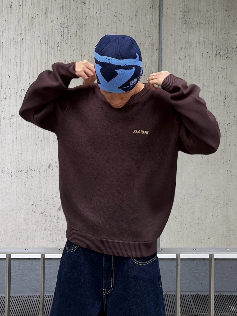 ブラウン系のニット/セーター、ブルー系のデニムパンツ、ブルー系のキャップを着用したメンズの秋コーディネートの7枚目の写真