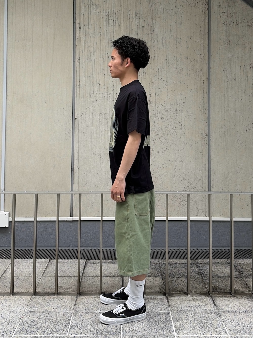 グリーン系のデニムパンツ、ブラック系のTシャツ/カットソーを着用したメンズの春コーディネートの2枚目の写真