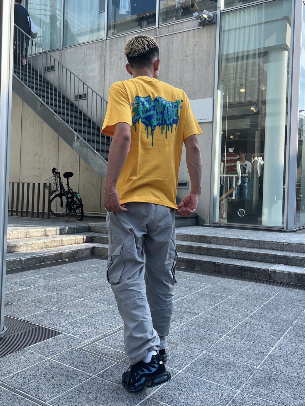 イエロー系のTシャツ/カットソー、グレー系のカーゴパンツを着用したメンズの夏コーディネートの5枚目の写真