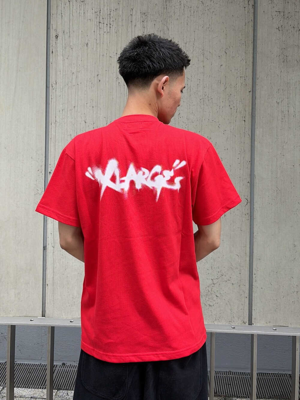 レッド系のTシャツ/カットソー、グレー系のスウェットパンツを着用したメンズの夏コーディネートの8枚目の写真