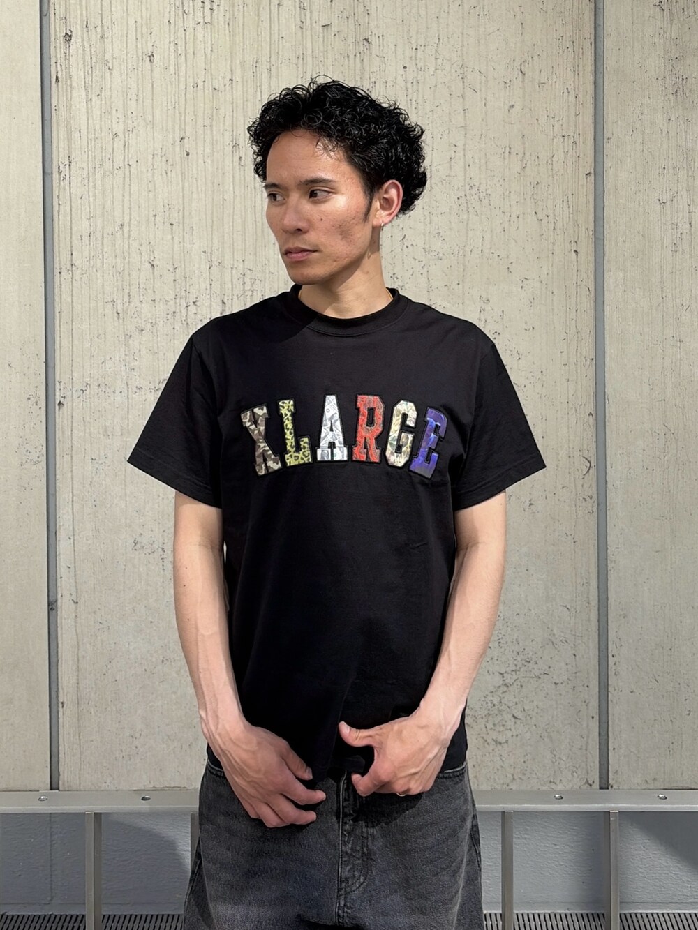 ブラック系のTシャツ/カットソー、ブルー系のデニムパンツを着用したメンズの春コーディネートの6枚目の写真