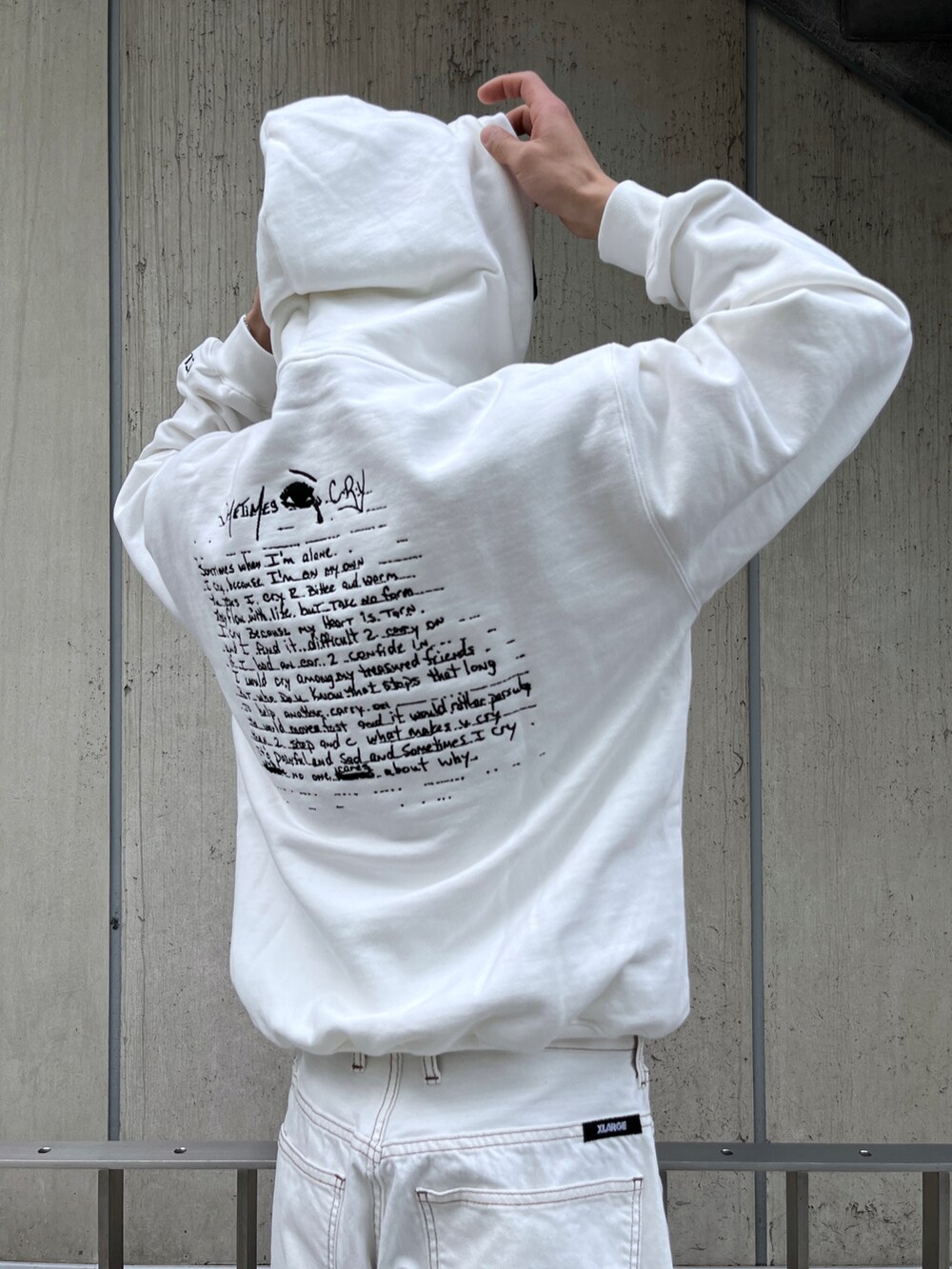 ホワイト系のパーカー、ブルー系のデニムパンツ、ブラック系のニットキャップ/ビーニーを着用したメンズの冬コーディネートの2枚目の写真