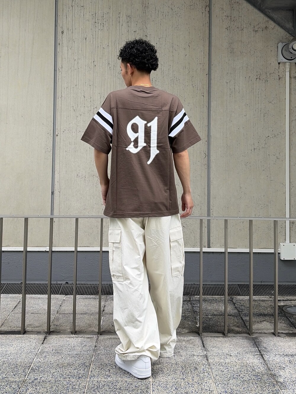ブラウン系のTシャツ/カットソー、ホワイト系のカーゴパンツを着用したメンズの夏コーディネートの4枚目の写真