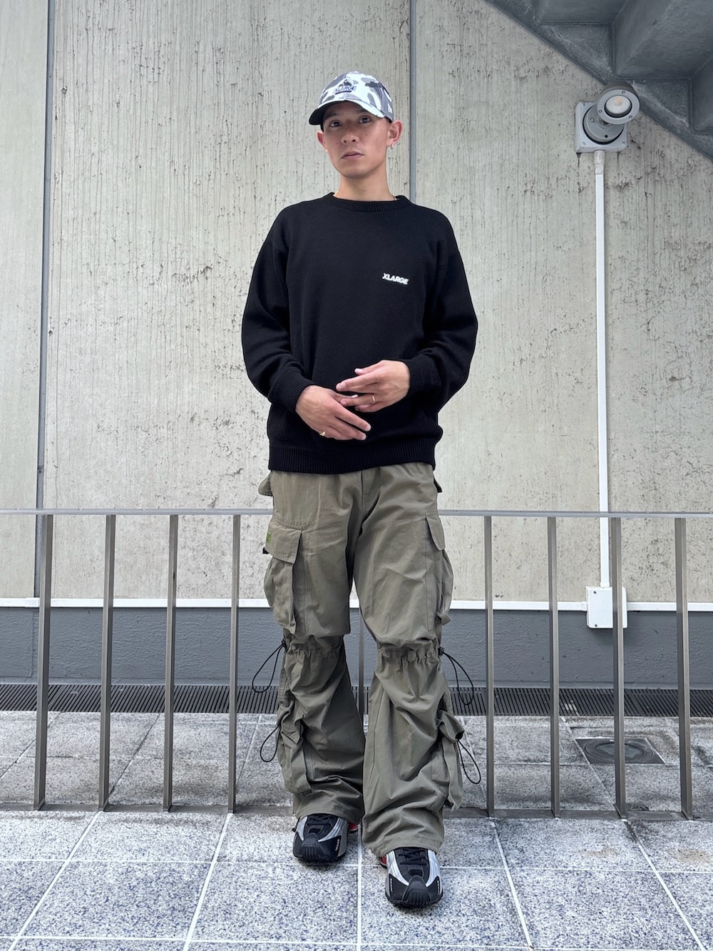 ブラック系のニット/セーター、グリーン系のカーゴパンツ、その他のキャップを着用したメンズの秋コーディネートの2枚目の写真