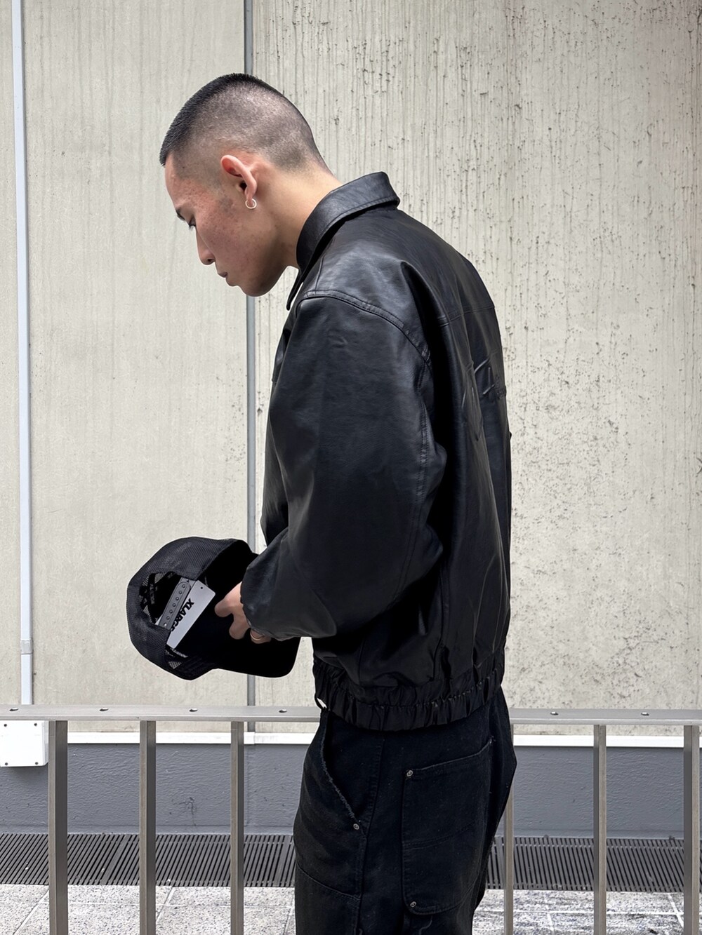 ブラック系のその他アウター、ブラウン系のその他パンツ、ブラック系のキャップを着用したメンズの冬コーディネートの8枚目の写真