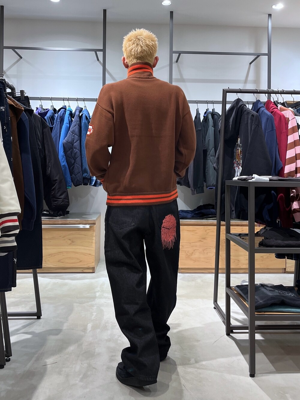 ブラック系のデニムパンツ、ブラウン系のニット/セーターを着用したメンズの秋コーディネートの4枚目の写真