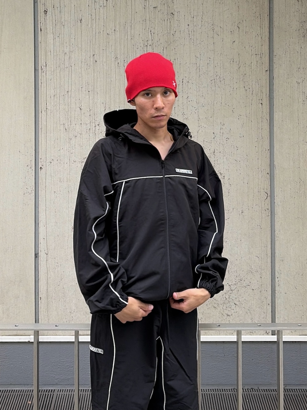 ブラック系のブルゾン、ブラック系のその他パンツ、レッド系のニットキャップ/ビーニーを着用したメンズの秋コーディネートの8枚目の写真