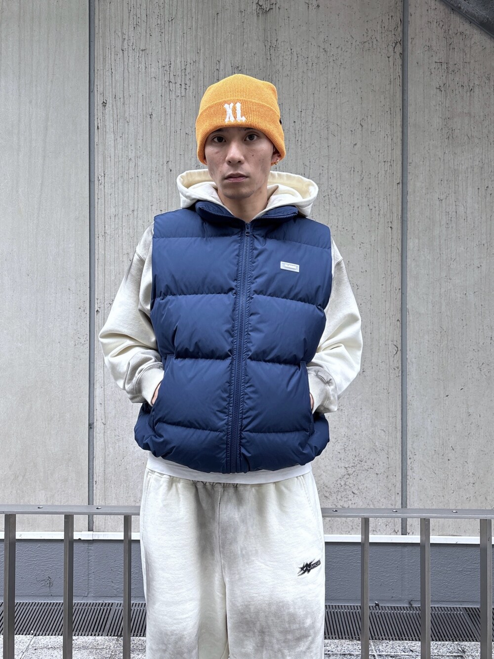 ブルー系のベスト、ホワイト系のパーカー、ホワイト系のスウェットパンツを着用したメンズの秋コーディネートの5枚目の写真