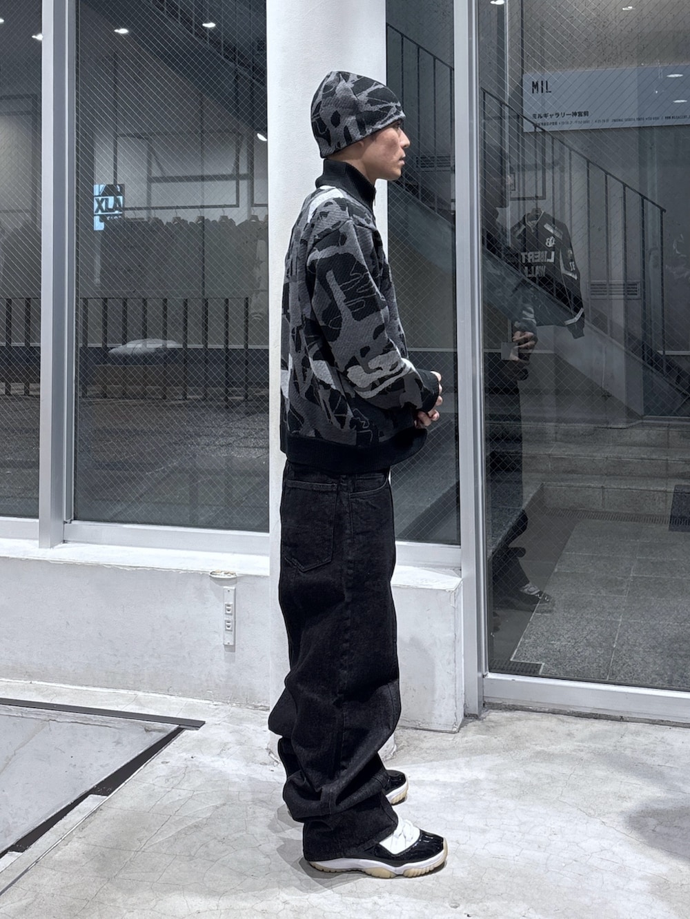 ブラック系のニット/セーター、ブラック系のデニムパンツ、ブラック系のニットキャップ/ビーニーを着用したメンズの秋コーディネートの3枚目の写真