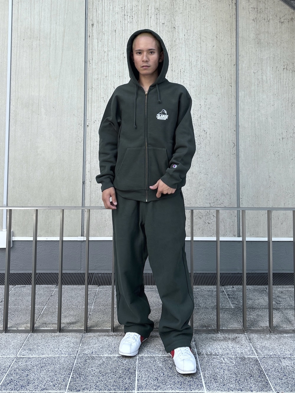 グリーン系のパーカー、グリーン系のスウェットパンツ、ブラック系のキャップを着用したメンズの秋コーディネートの2枚目の写真