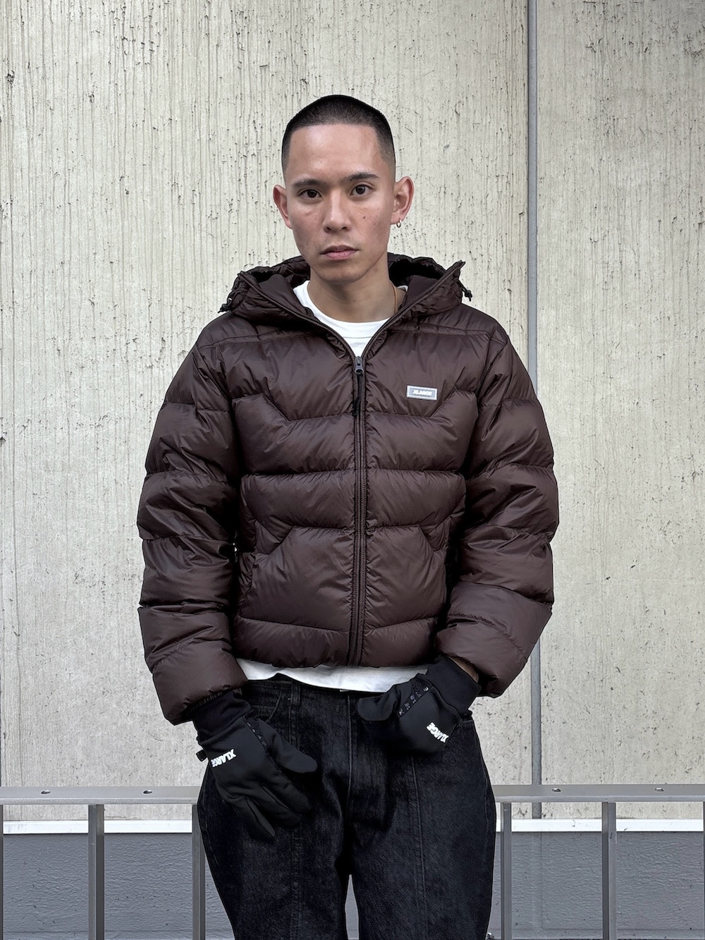 ブラウン系のダウンジャケット/コート、ブラック系のデニムパンツ、ブラック系の手袋を着用したメンズの秋コーディネートの6枚目の写真