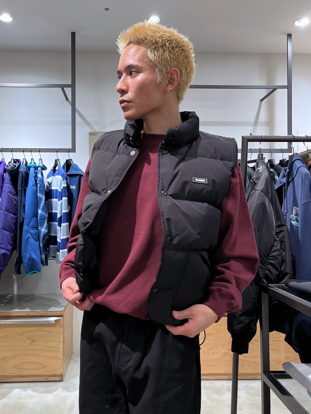レッド系のスウェット、ブラック系のその他パンツ、ブラック系のダウンベストを着用したメンズの秋コーディネートの10枚目の写真