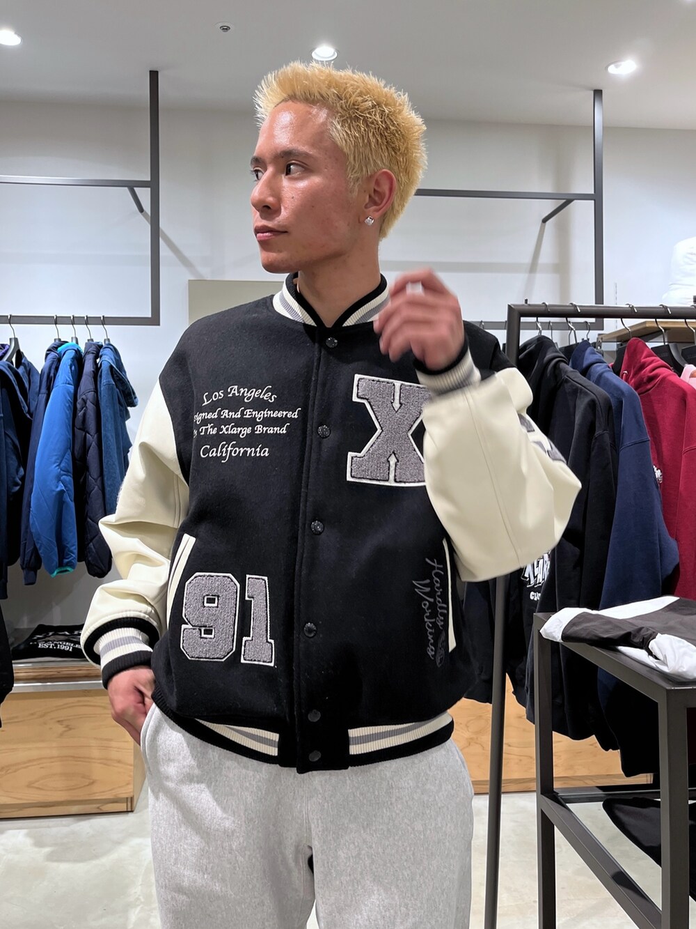 ブルー系のスタジャン、ブラック系のスウェットパンツを着用したメンズの秋コーディネートの5枚目の写真