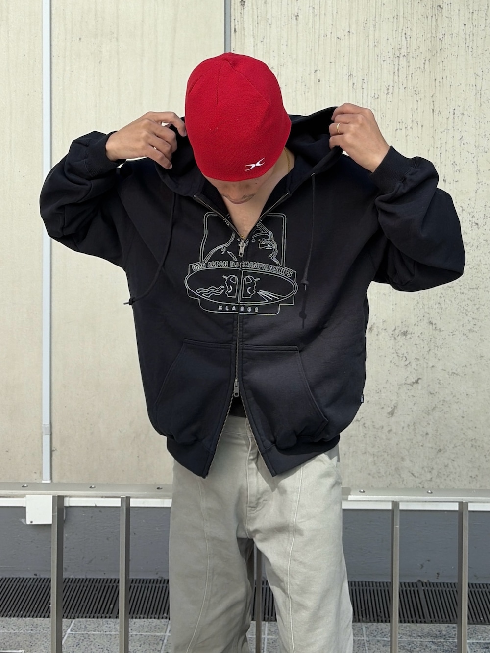 グレー系のその他パンツ、レッド系のニットキャップ/ビーニーを着用したメンズの夏コーディネートの7枚目の写真