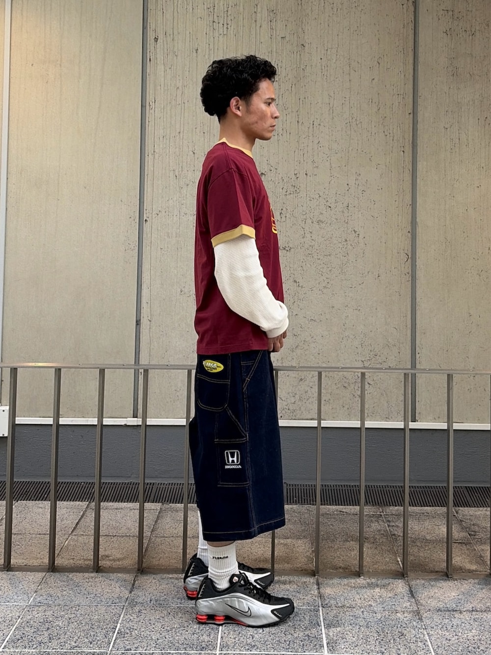 レッド系のTシャツ/カットソー、ブルー系のデニムパンツ、ホワイト系のTシャツ/カットソーを着用したメンズの春コーディネートの3枚目の写真