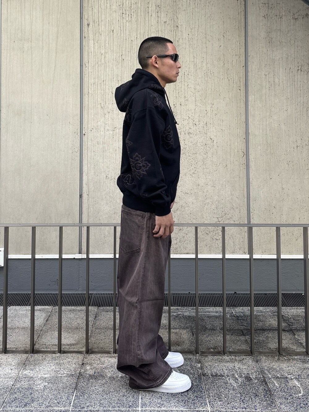 ブラック系のパーカー、ブラウン系のデニムパンツを着用したメンズの冬コーディネートの2枚目の写真