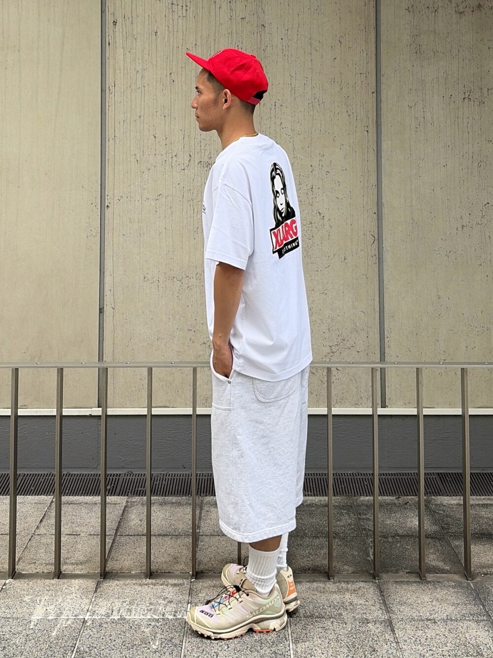 グレー系のスウェットパンツ、レッド系のキャップを着用したメンズの夏コーディネートの2枚目の写真