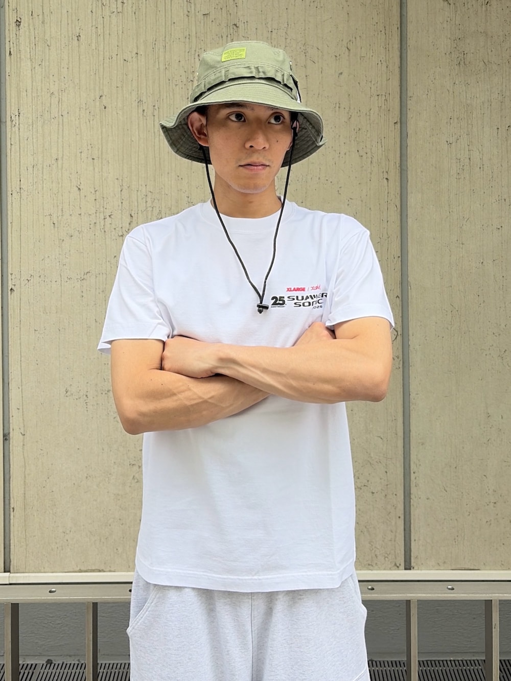 グレー系のスウェットパンツ、ブルー系のベルト、ブラック系のハットを着用したメンズの夏コーディネートの5枚目の写真