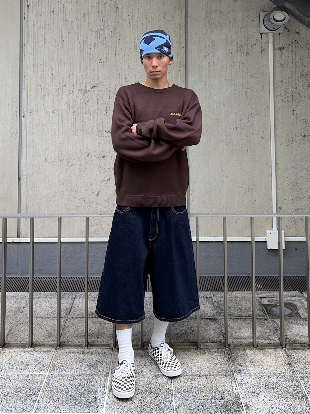 ブラウン系のニット/セーター、ブルー系のデニムパンツ、ブルー系のキャップを着用したメンズの秋コーディネートの2枚目の写真