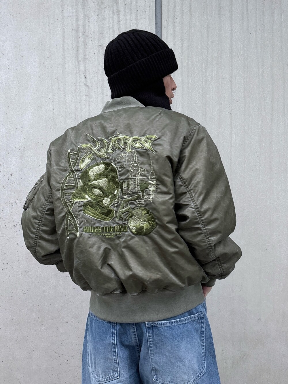 ブラック系のMA-1、ブルー系のデニムパンツ、ブラック系のニットキャップ/ビーニーを着用したメンズの秋コーディネートの6枚目の写真