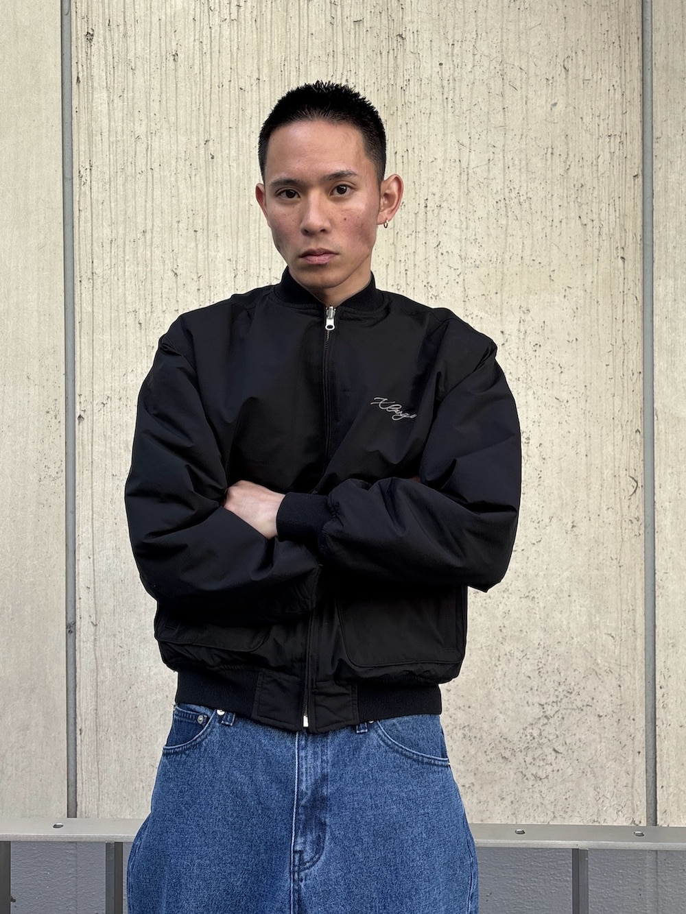 ブラック系のブルゾン、ブルー系のデニムパンツを着用したメンズの冬コーディネートの5枚目の写真