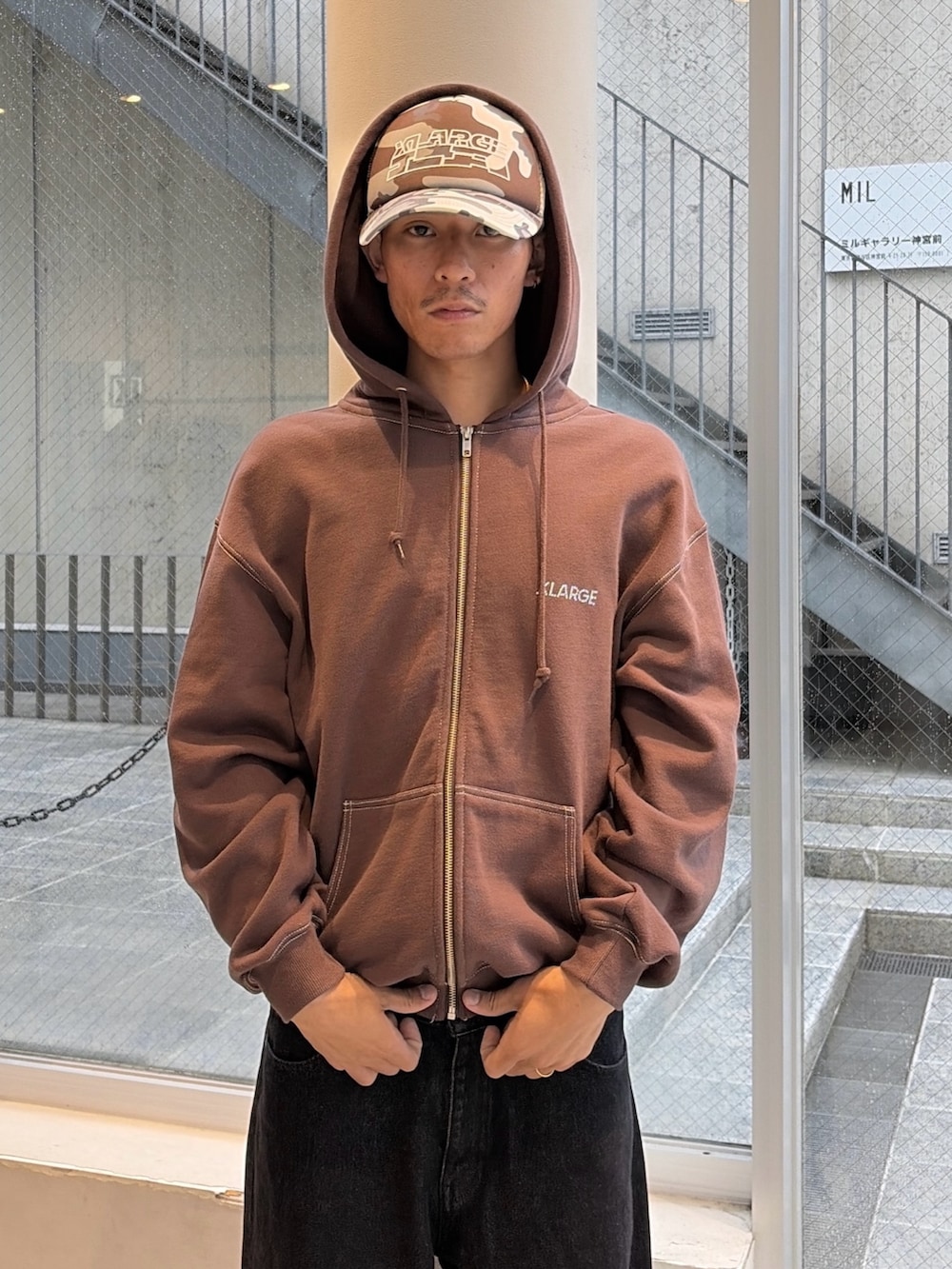 ブラウン系のパーカー、ブルー系のデニムパンツ、ブラック系のキャップを着用したメンズの秋コーディネートの8枚目の写真