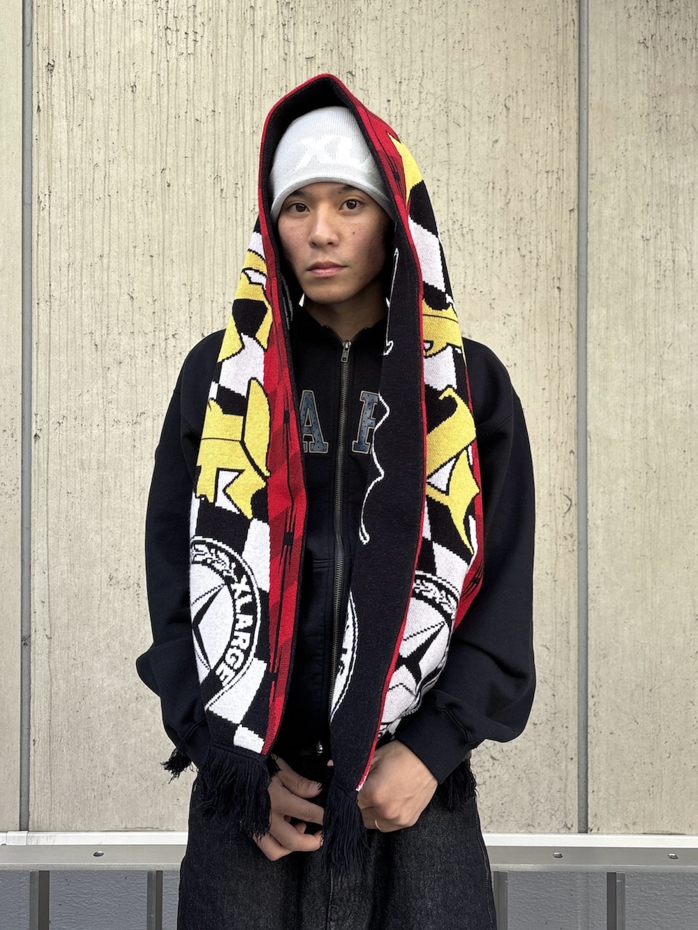 ブルー系のデニムパンツ、ブラック系のパーカー、ピンク系のニットキャップ/ビーニーを着用したメンズの冬コーディネートの6枚目の写真