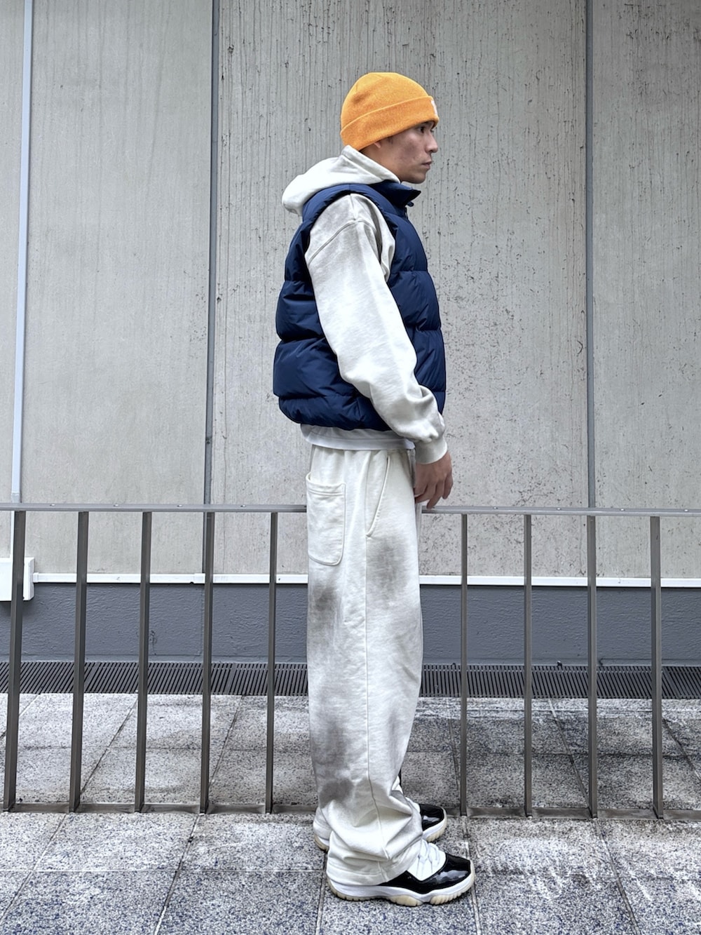 ブルー系のベスト、ホワイト系のパーカー、ホワイト系のスウェットパンツを着用したメンズの秋コーディネートの3枚目の写真