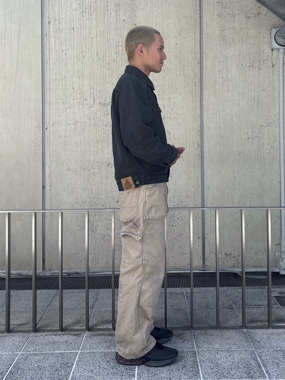 ブラック系のデニムジャケット、ベージュ系のその他パンツを着用したメンズの春コーディネートの3枚目の写真
