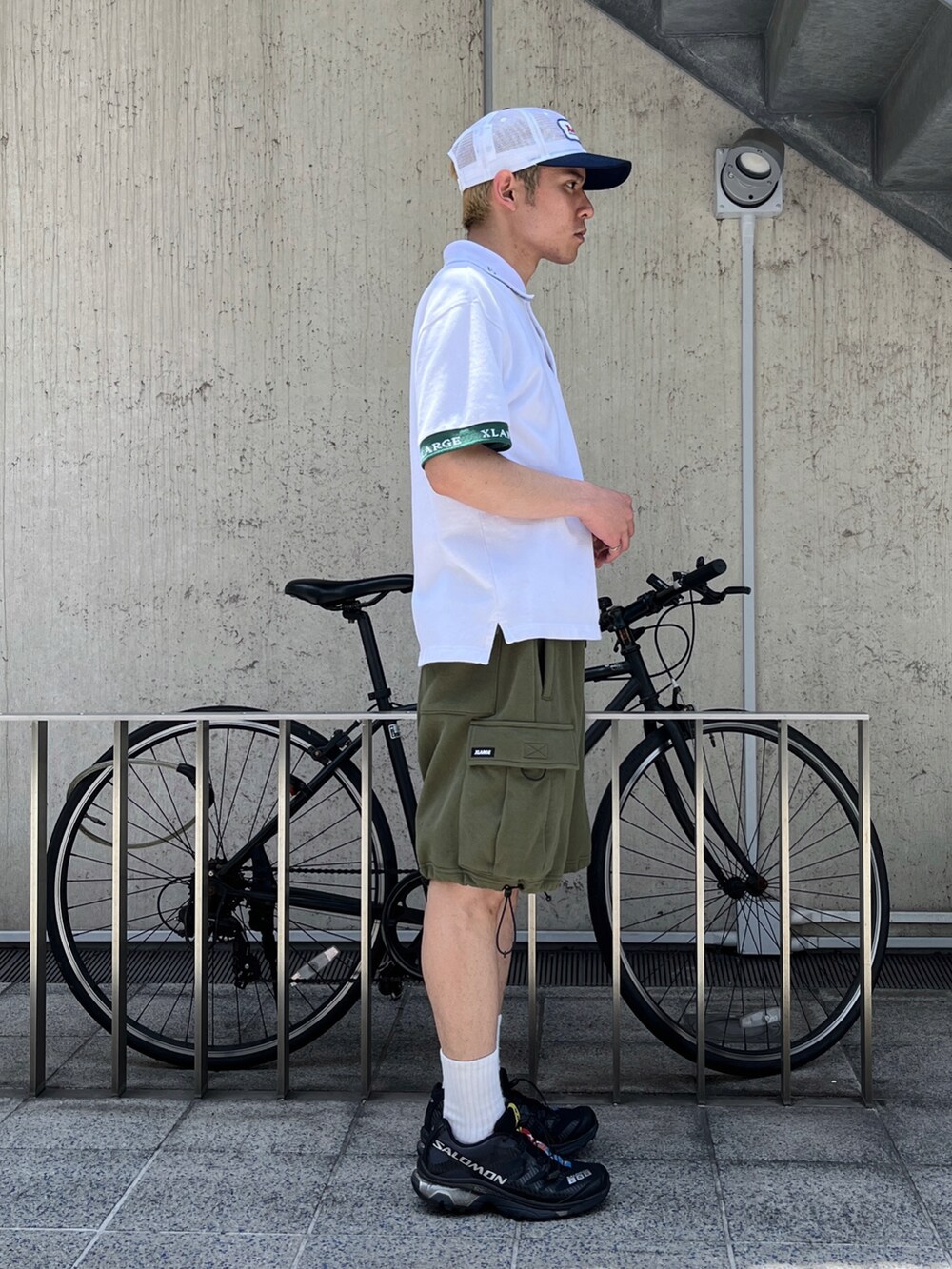 ホワイト系のTシャツ/カットソー、グリーン系のカーゴパンツを着用したメンズの春コーディネートの4枚目の写真