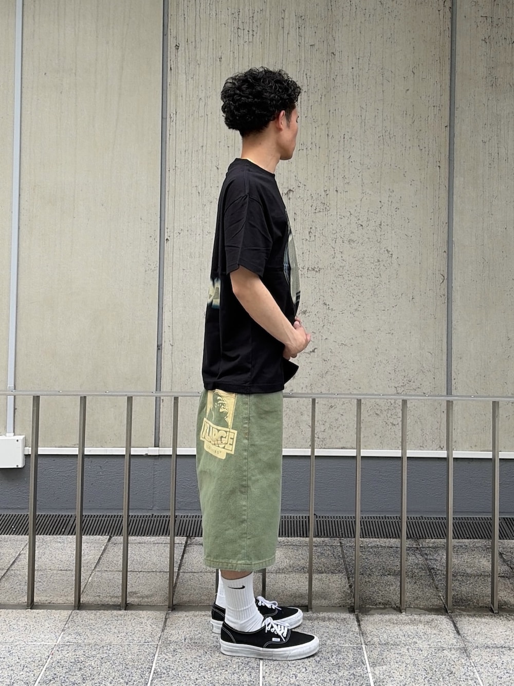 グリーン系のデニムパンツ、ブラック系のTシャツ/カットソーを着用したメンズの春コーディネートの3枚目の写真