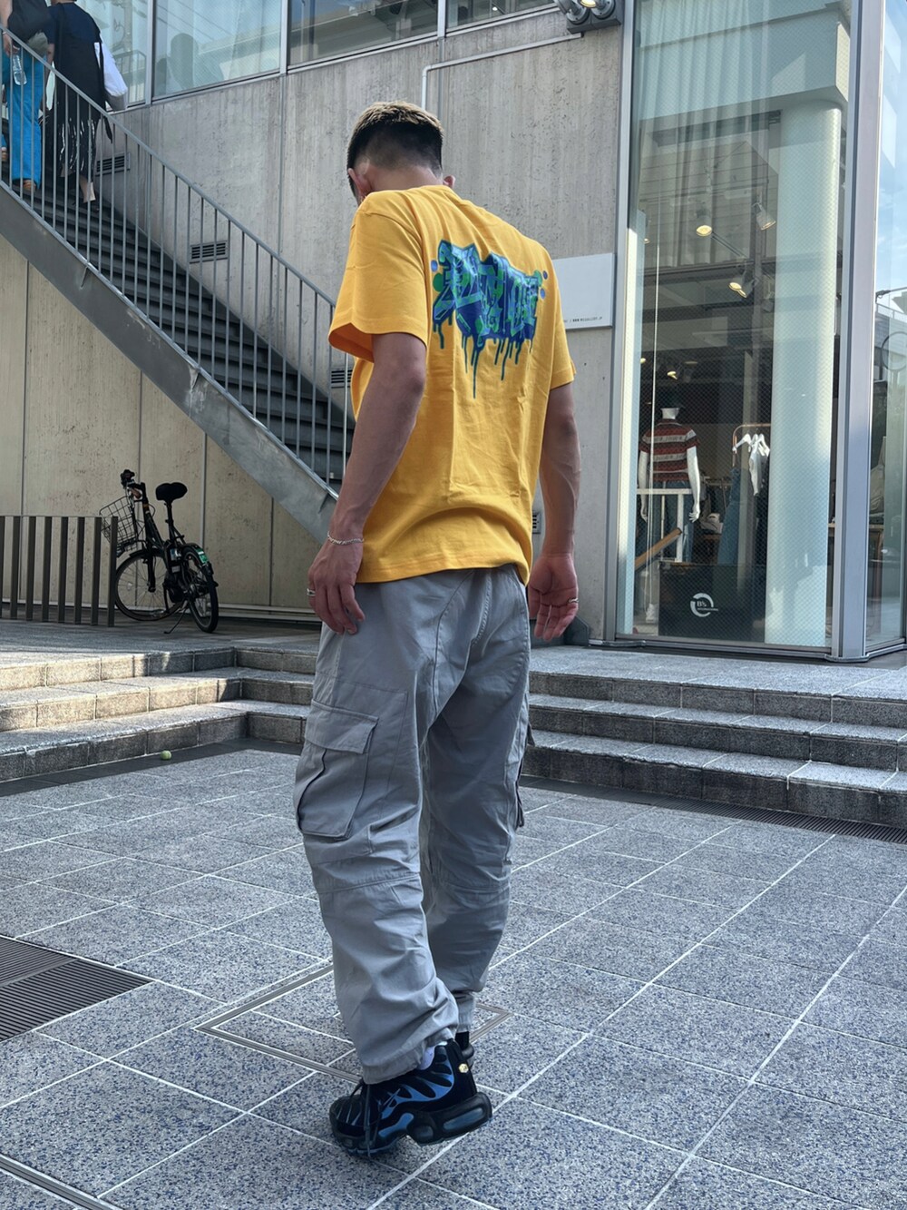 イエロー系のTシャツ/カットソー、グレー系のカーゴパンツを着用したメンズの夏コーディネートの4枚目の写真