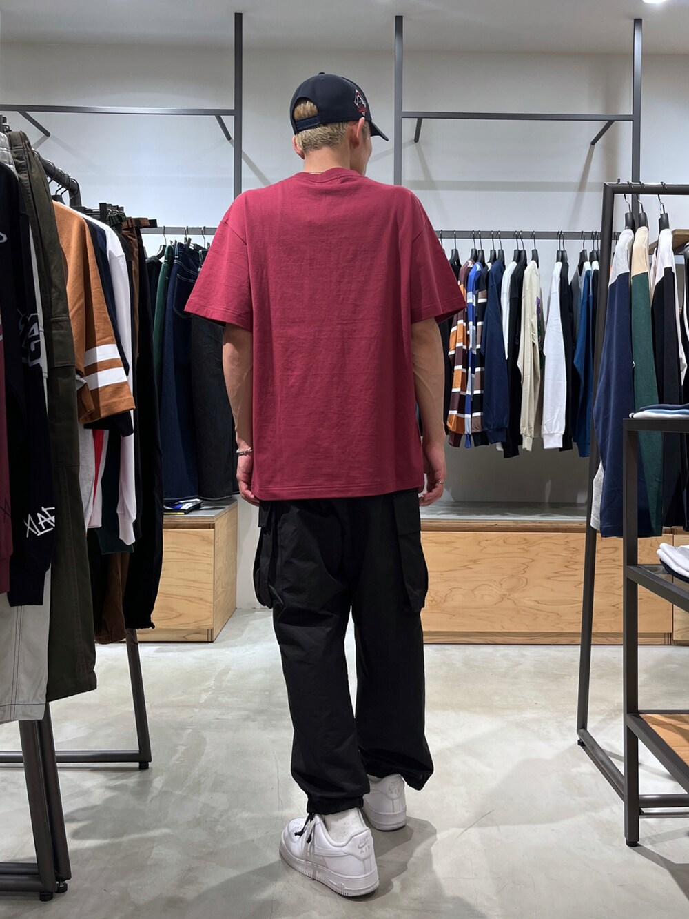 レッド系のTシャツ/カットソー、ブラック系のカーゴパンツ、ブルー系のキャップを着用したメンズの夏コーディネートの4枚目の写真