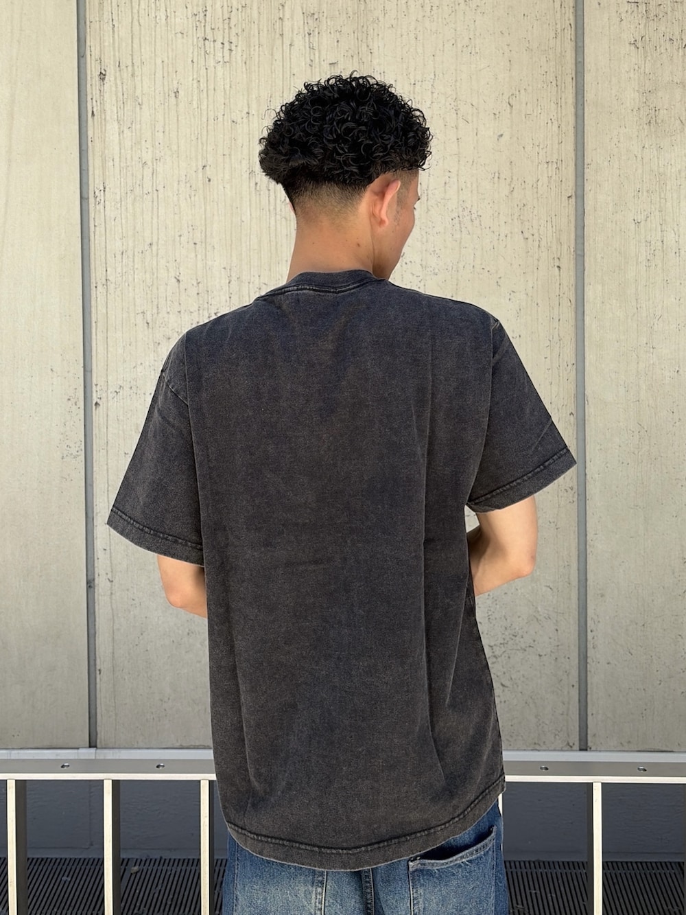 ブラック系のTシャツ/カットソー、ブルー系のデニムパンツを着用したメンズの夏コーディネートの6枚目の写真