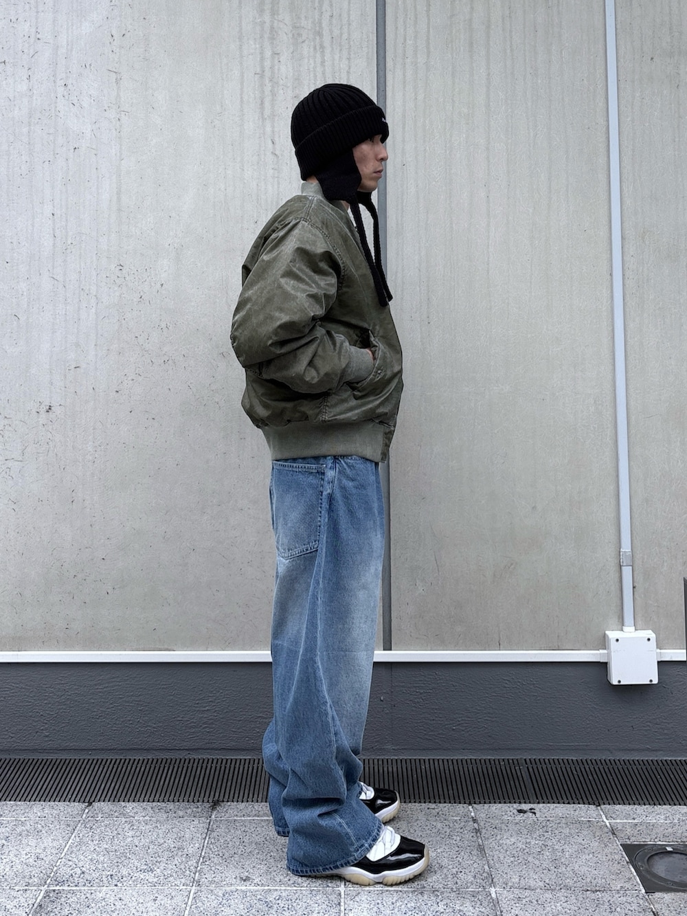 ブラック系のMA-1、ブルー系のデニムパンツ、ブラック系のニットキャップ/ビーニーを着用したメンズの秋コーディネートの3枚目の写真