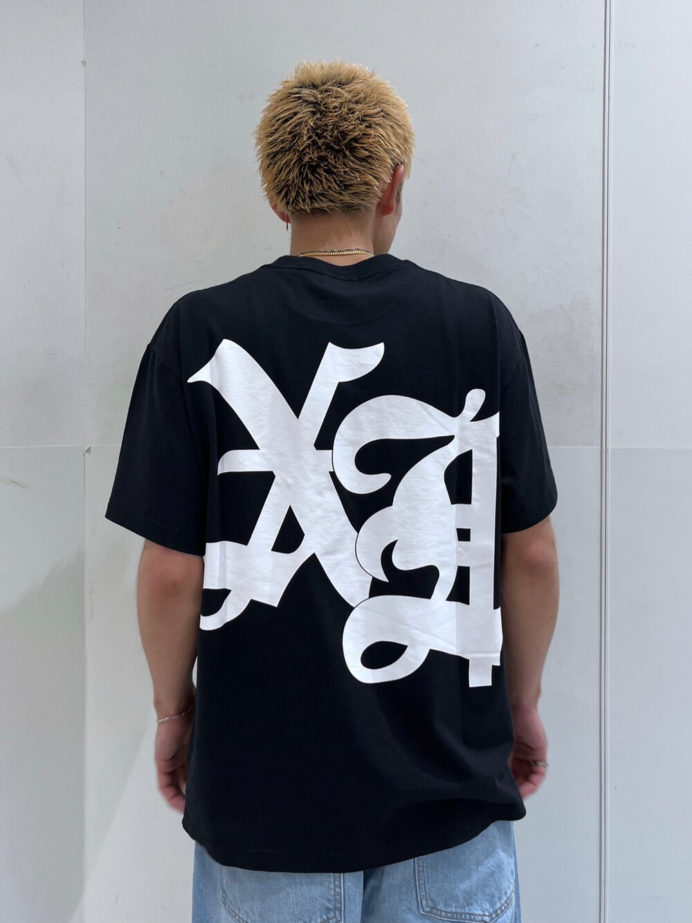 ブラック系のTシャツ/カットソー、ホワイト系のデニムパンツを着用したメンズの夏コーディネートの5枚目の写真