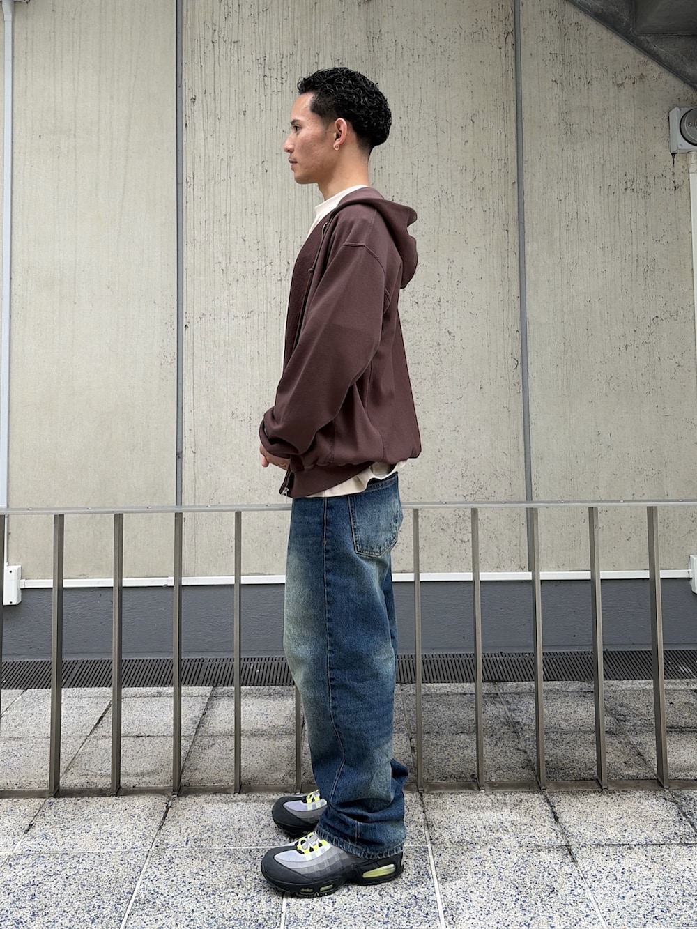 ベージュ系のTシャツ/カットソー、ブラウン系のパーカー、ブルー系のデニムパンツを着用したメンズの春コーディネートの2枚目の写真