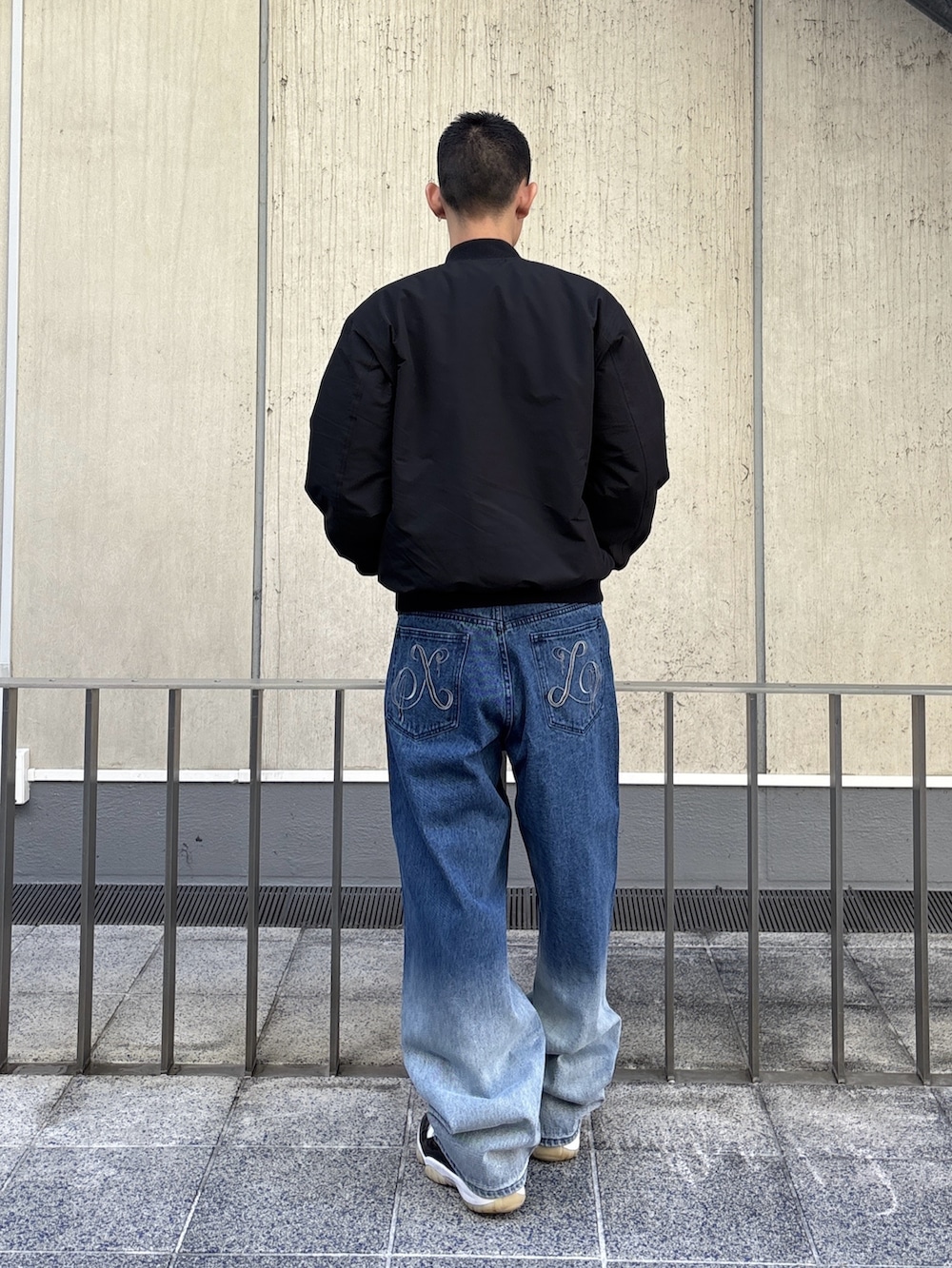 ブラック系のブルゾン、ブルー系のデニムパンツを着用したメンズの冬コーディネートの4枚目の写真