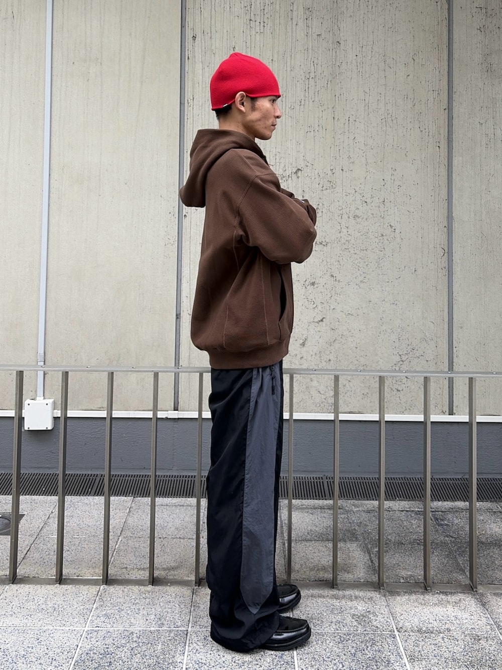 ブラウン系のパーカー、レッド系のその他パンツ、レッド系のニットキャップ/ビーニーを着用したメンズの秋コーディネートの5枚目の写真