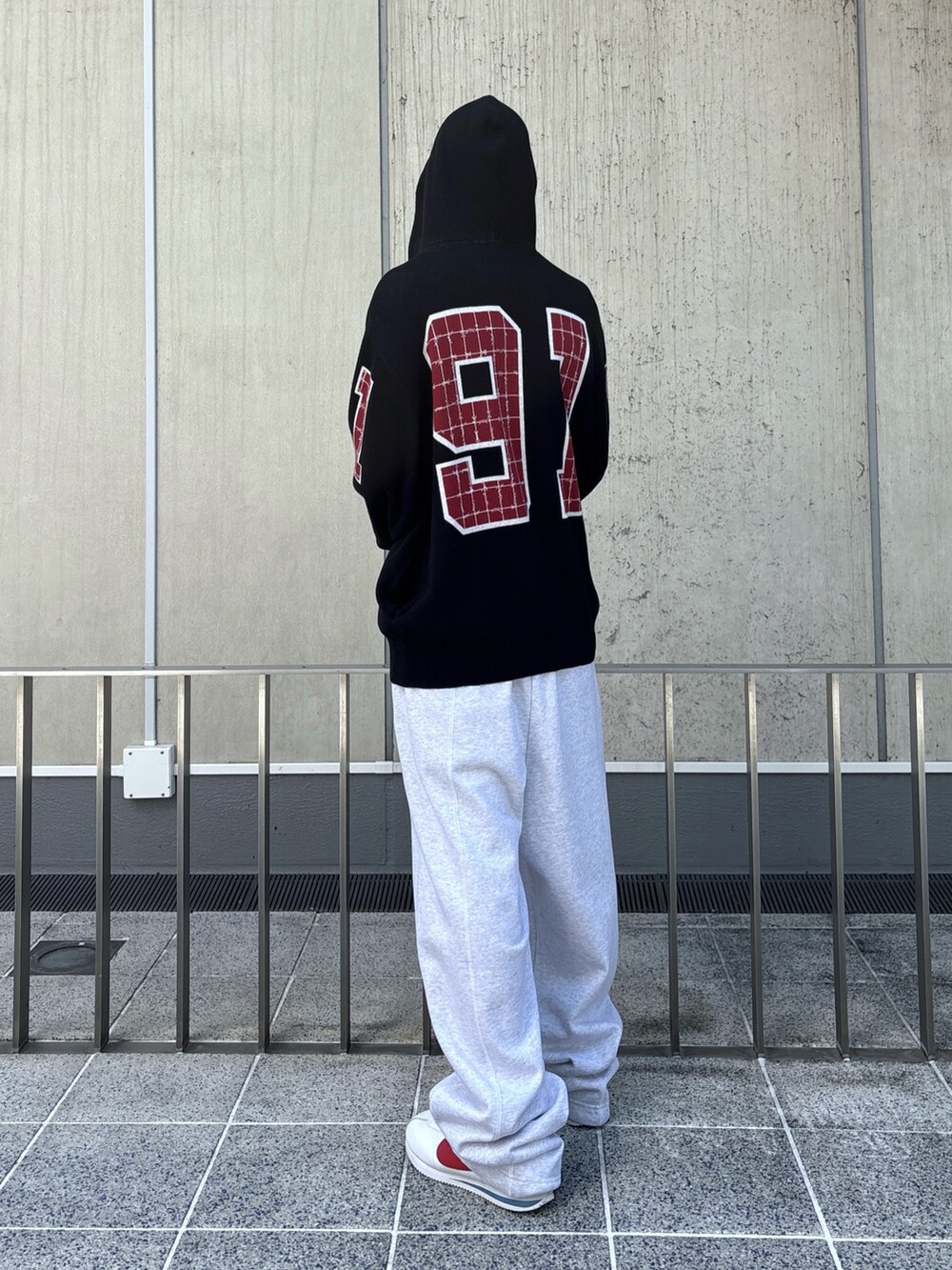 ブラック系のニット/セーター、グレー系のスウェットパンツを着用したメンズの秋コーディネートの4枚目の写真