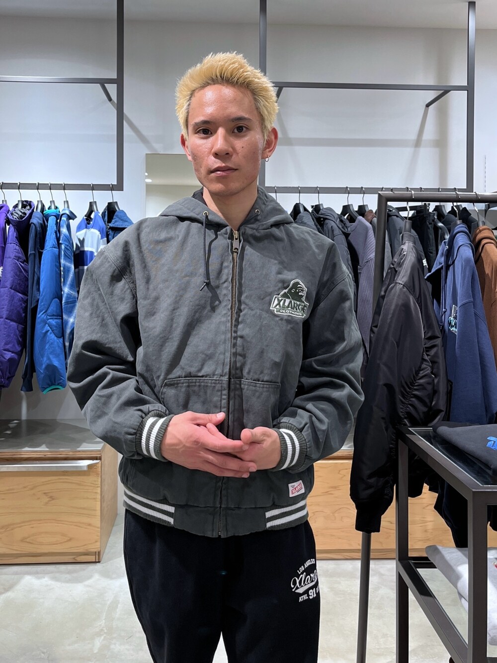 グリーン系のブルゾン、グレー系のスウェットパンツを着用したメンズの秋コーディネートの5枚目の写真